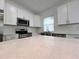 Close-up of a modern kitchen featuring white quartz countertops, stainless steel appliances, and subway tile backsplash at 183 Wright Drive, Rotonda West, FL 33947