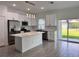 Modern kitchen boasts a center island, stainless steel appliances, and easy access to outdoor space at 183 Wright Drive, Rotonda West, FL 33947
