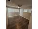 Bedroom with wood-look floors, a ceiling fan, and bright windows provides a comfortable space at 7403 Foxbloom Dr, Port Richey, FL 34668