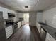 Kitchen featuring white cabinetry, stainless steel appliances, and new wood laminate flooring at 7403 Foxbloom Dr, Port Richey, FL 34668
