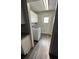 Bright laundry room features wood-look floors, a modern washing machine, and white cabinets for storage at 7403 Foxbloom Dr, Port Richey, FL 34668