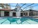 Beautiful backyard pool surrounded by a screen enclosure and a grassy area at 4907 Parson Brown Ln, Palm Harbor, FL 34684
