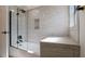 Tiled bathtub shower combination with glass shower door and a built-in seat at 4907 Parson Brown Ln, Palm Harbor, FL 34684