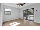 This bedroom features plank flooring, a ceiling fan, an exterior entrance, and neutral paint at 4907 Parson Brown Ln, Palm Harbor, FL 34684