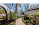 Inviting front entrance featuring a walkway through landscaped beds and white archway at 4907 Parson Brown Ln, Palm Harbor, FL 34684