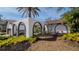 Unique front elevation with archways and xeriscaping enhancing curb appeal at 4907 Parson Brown Ln, Palm Harbor, FL 34684