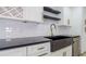 Modern kitchen with black countertops, black sink, and gold hardware at 4907 Parson Brown Ln, Palm Harbor, FL 34684