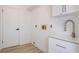 Laundry room with modern cabinets, plank flooring, door and faucet at 4907 Parson Brown Ln, Palm Harbor, FL 34684
