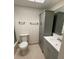Bathroom features a white toilet, vanity, and a grey cabinet at 215 Valencia Blvd # 212, Belleair Bluffs, FL 33770
