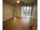 Sunlit bedroom with wood floors and a sliding glass door to a balcony at 215 Valencia Blvd # 212, Belleair Bluffs, FL 33770
