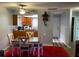 Cozy dining room with a red rug and a dining table that leads to a kitchen and a ceiling fan at 215 Valencia Blvd # 212, Belleair Bluffs, FL 33770