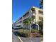 Condominium exterior with lush landscaping, parking lot, and signage at 215 Valencia Blvd # 212, Belleair Bluffs, FL 33770
