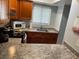 Efficient kitchen features warm cabinets, granite countertops, and modern appliances at 215 Valencia Blvd # 212, Belleair Bluffs, FL 33770