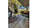 Landscaped walkway featuring concrete sidewalk, rocks, trees, and a small bench at 215 Valencia Blvd # 212, Belleair Bluffs, FL 33770