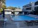 A pristine community pool surrounded by lounge chairs, tables, and landscaping at 215 Valencia Blvd # 212, Belleair Bluffs, FL 33770