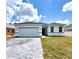 Charming single-story home with a two-car garage, light exterior, and a beautifully paved driveway at 104 Australian Dr, Rotonda West, FL 33947