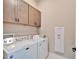 Laundry room with washer, dryer, upper cabinets, and neutral paint at 5842 Shorebird Br, Land O Lakes, FL 34638