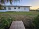 The lush backyard features a wooden pathway surrounded by greenery, offering a serene outdoor space at 460 Creek Lane Dr, Englewood, FL 34223