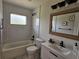 Stylish bathroom featuring a tub, tiled walls, vanity, and modern fixtures for a relaxing experience at 460 Creek Lane Dr, Englewood, FL 34223