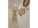 Bright hallway featuring tan tile flooring and decorative straw baskets hanging on the wall at 460 Creek Lane Dr, Englewood, FL 34223