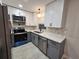 Stylish kitchen featuring gray lower cabinets, white upper cabinets and modern stainless steel appliances at 460 Creek Lane Dr, Englewood, FL 34223