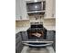 Modern oven with stovetop, stylish backsplash, and countertops in a well-lit kitchen at 460 Creek Lane Dr, Englewood, FL 34223