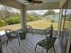 Screened-in porch featuring four wicker chairs and decorative tile flooring, perfect for enjoying the outdoors at 460 Creek Lane Dr, Englewood, FL 34223