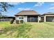 Backyard view featuring a well-maintained lawn, green shrubbery, and a screened patio at 5142 Beacon Light Pt, Land O Lakes, FL 34638