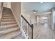 Carpeted staircase leading to an open-concept living space with wood-look floors at 5142 Beacon Light Pt, Land O Lakes, FL 34638