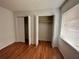 Bedroom featuring wood floors, white walls, window with blinds and dual door closets at 7522 Needle Leaf Pl # 27, Tampa, FL 33617
