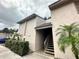 Condo exterior showcasing well maintained stucco walls, green shrubbery and stairs leading to the entrance at 7522 Needle Leaf Pl # 27, Tampa, FL 33617