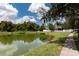 Picturesque view of a backyard pond with lush greenery, a walking path, and a glimpse of the home at 7139 Colony Pointe Dr, Riverview, FL 33578