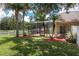 Backyard with screen enclosed lanai, hot tub, lush grass, and meticulous landscaping at 7139 Colony Pointe Dr, Riverview, FL 33578