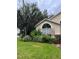 Charming home exterior features a large arched window framed by stone accents and lush, mature landscaping at 7139 Colony Pointe Dr, Riverview, FL 33578