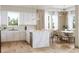 Open concept kitchen with white cabinets, marble island, stainless appliances, and dining area at 125 Baytree Dr, Rotonda West, FL 33947