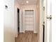 A hallway with wood floors and doors leading to a pantry and bathroom at 7316 Samuel Ivy Dr, Tampa, FL 33619