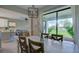 Bright dining room with a wooden table, four chairs, and a large sliding glass door overlooking backyard at 8292 Shooting Star Rd, Sarasota, FL 34241