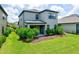 Exterior rear view of a two-story home with a well-maintained lawn and mature landscaping at 8292 Shooting Star Rd, Sarasota, FL 34241