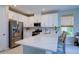 Bright kitchen featuring stainless steel appliances, an island bar, and white cabinetry at 8292 Shooting Star Rd, Sarasota, FL 34241