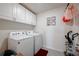 Functional laundry room with white washer, dryer, and overhead cabinets at 1236 7Th Nw Ave, Ruskin, FL 33570