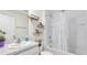 This bathroom has shelves above the toilet and a shower/tub combo with a shower curtain at 7522 Rosewood Garden Loop, Tampa, FL 33637