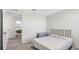 Carpeted bedroom featuring a simple bed and view into a second room at 7522 Rosewood Garden Loop, Tampa, FL 33637