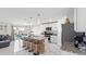 Open-concept kitchen with a central island, bar seating, stainless steel appliances, and seamless connection to the living area at 7522 Rosewood Garden Loop, Tampa, FL 33637