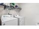 Bright laundry room featuring a white washer and dryer set, plus wire shelving for storage at 7522 Rosewood Garden Loop, Tampa, FL 33637