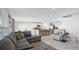 Open living space featuring tile floors, a comfortable sectional, a view of the kitchen, and a nearby staircase at 7522 Rosewood Garden Loop, Tampa, FL 33637