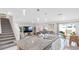 Inviting living room with an island, bar stools, kitchen view, adjacent dining area, and staircase to the upper level at 7522 Rosewood Garden Loop, Tampa, FL 33637