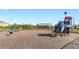 Community playground with swings, slide, and spring riders on a wood chip surface at 7522 Rosewood Garden Loop, Tampa, FL 33637