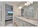 Bathroom with double vanity and large mirror, with view into bright bedroom at 19195 Iron Topsail Isle, Land O Lakes, FL 34638