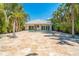 Spacious backyard with travertine pavers, a refreshing pool, and lush tropical landscaping at 115 N Blvd Of The Presidents, Sarasota, FL 34236