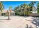 Large travertine patio leading to pool and home, complemented by tropical landscaping at 115 N Blvd Of The Presidents, Sarasota, FL 34236